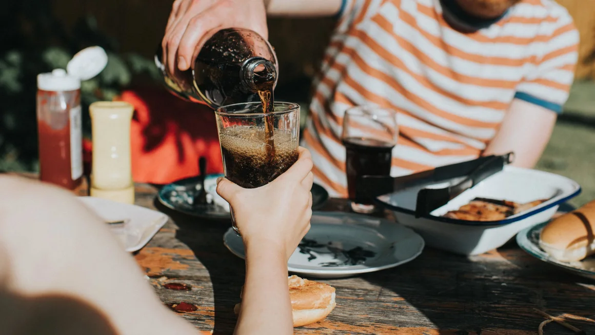 Assorted sugary drinks in bottles and glasses, emphasizing their link to higher death risks and healthier alternatives.