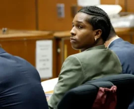 A$AP Rocky in a courtroom setting, surrounded by legal documents and media cameras, representing his high-profile assault trial