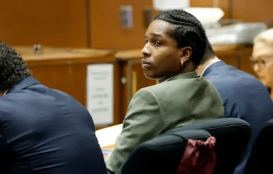 A$AP Rocky in a courtroom setting, surrounded by legal documents and media cameras, representing his high-profile assault trial