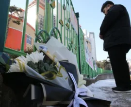 A South Korean classroom with police tape and a chalkboard in the background, symbolizing the tragic incident of a teacher arrested for fatally stabbing an eight-year-old child